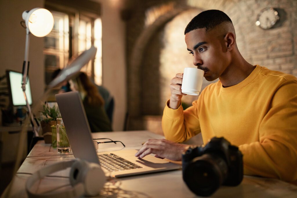 Homem negro tomando café e analisando os dados da agência de marketing digital no Rio de Janeiro