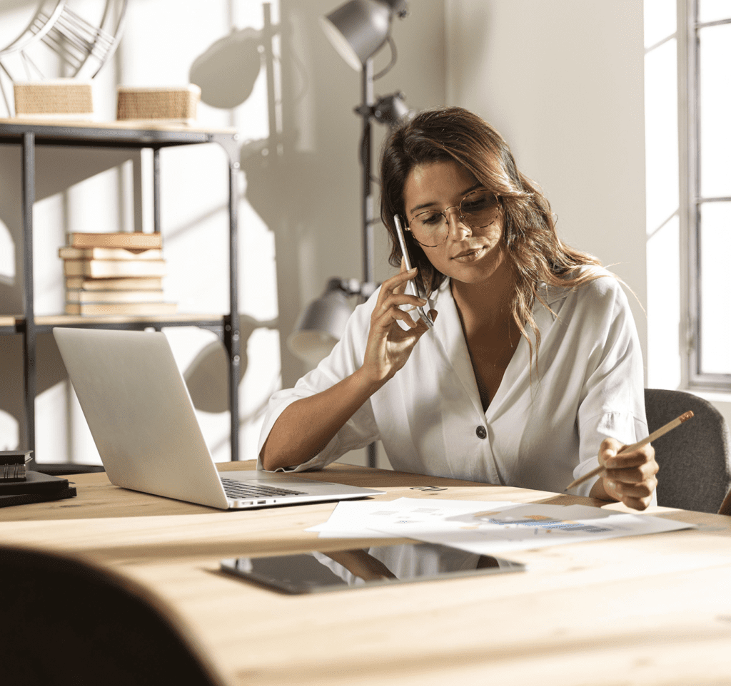 Mulher sentada no escritório, ligando para uma agência de marketing digital
